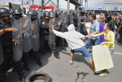 Protesters taunt riot police in the northern industrial city of Monterrey, Mexico, on Tuesday.  Officials say the protests are organized by drug cartels that they say are trying to disrupt the government’s anti-drug crackdown. (Associated Press / The Spokesman-Review)