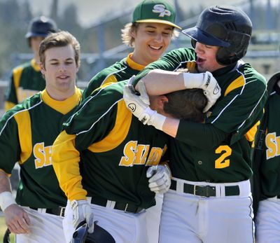 Shadle Park's, Evan Douglas gets put in a headlock by teammate Levi McBournie (2) after Douglas hit a first-inning grand slam home run and crossed home plate against the Mead Panthers, April 5, 2011 in Mead. It is the second grand slam for the freshman third baseman this season. (Dan Pelle / The Spokesman-Review)