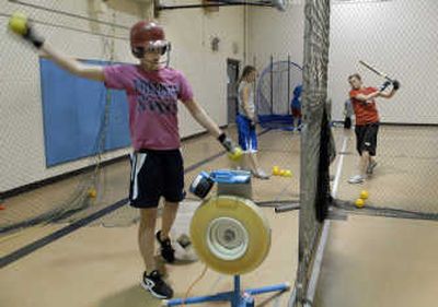 
Freeman senior all-league pitcher Casey Olson feeds balls into the pitching machine as the team practiced inside in preparation for this weekend's state tournament at Franklin Park in Spokane.
 (J. BART RAYNIAK / The Spokesman-Review)