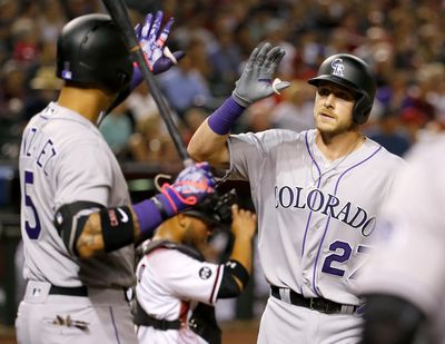 Colorado Rockies shortstop Trevor Story, right, became first player in MLB history to hit a home run in each of his first three games. (Associated Press)