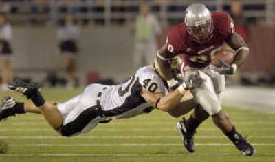 
Washington State running back Kevin McCall attempts to slip the tackle of Idaho's David Vobora during Saturday night's non-conference game at Martin Stadium. 
 (Christopher Anderson / The Spokesman-Review)