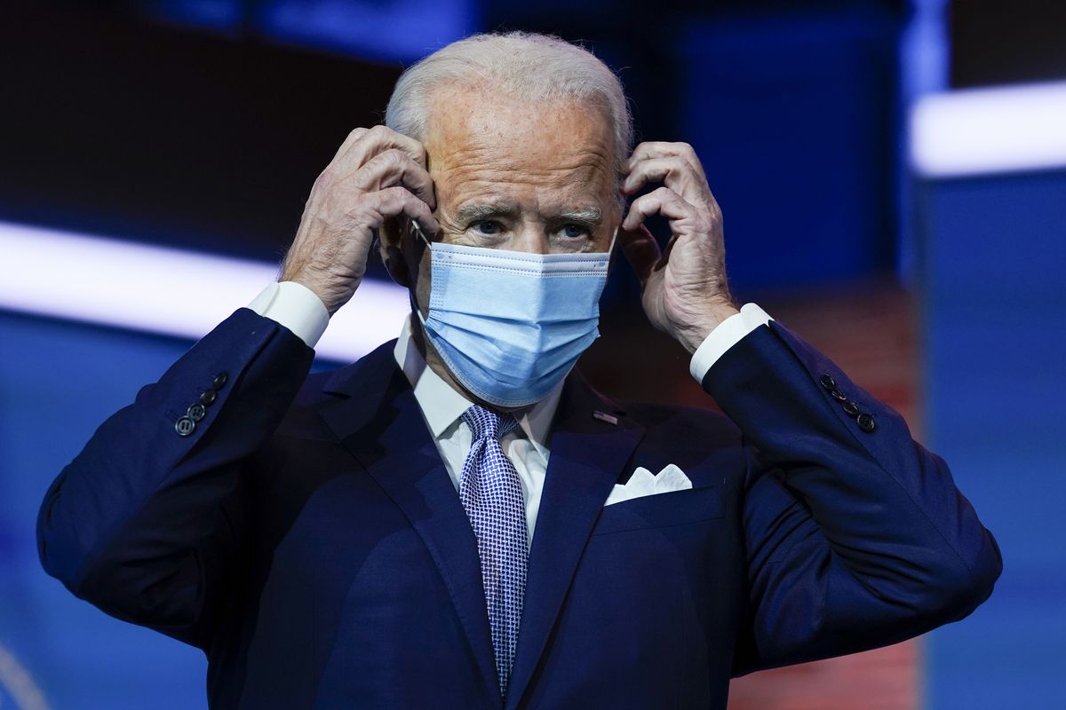 FILE - In this Nov. 24, 2020, file photo President-elect Joe Biden puts on his face mask after introducing nominees and appointees to key national security and foreign policy posts at The Queen theater in Wilmington, Del. Congress is bracing for Biden to move beyond the Trump administration’s state-by-state approach to the COVID-19 crisis and build out a national strategy to fight the pandemic and distribute the eventual vaccine. (Carolyn Kaster)