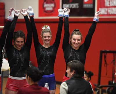 Mead gymnast Lexi Weller, right, and teammates address the judges before competing on the balance beam on Dec. 13, 2018, at North Central High. (Dan Pelle / The Spokesman-Review)