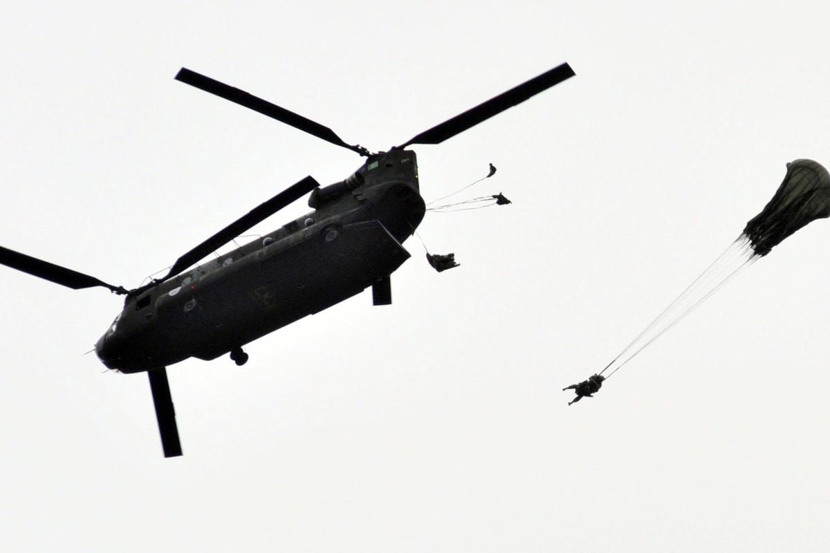 A Washington National Guard Chinook helicopter drops paratroopers and supplies for the Cascadia Rising drill Thursday. (Jim Camden / The Spokesman-Review)