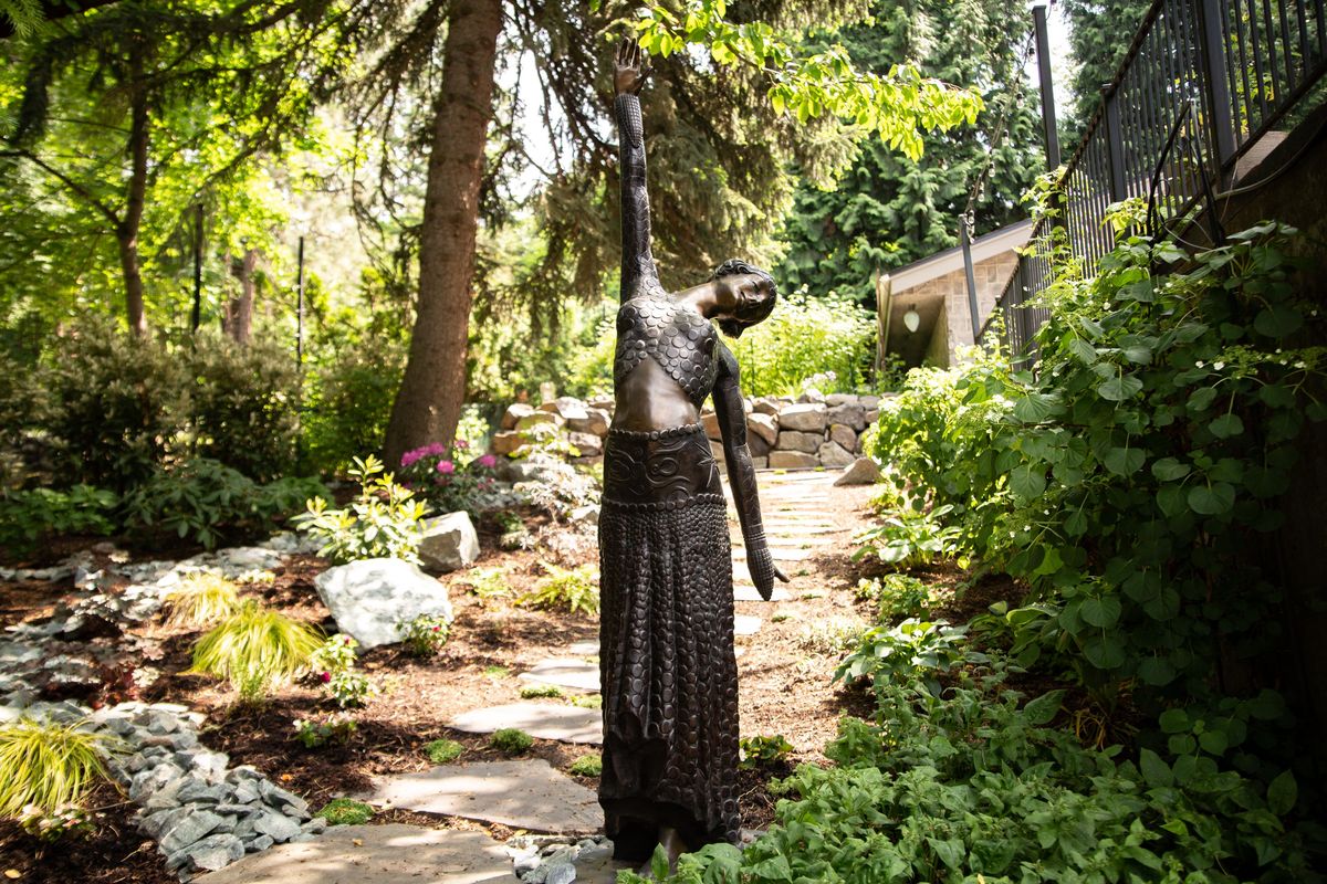 A 1920s era bronze statue of a dancer, purchased by Nancy Caputo in San Leandro, California is seen in the garden on a sunny May 29, 2019 at the residence of Jim Jackson and Caputo at 1122 E. 20th Avenue in Spokane, Wash. The property features one acre of intricate landscaping with many fountains, peaceful nooks for sitting, and a wide variety of flowers and vegetation. (Libby Kamrowski / The Spokesman-Review)