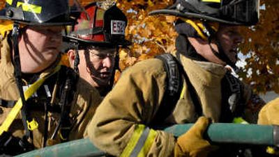 
Northern Lakes Fire District Lt. Mike Mather, center, works with new hires Phil Duzet, left, and Chris Kieres  at the station in Hayden. 
 (Kathy Plonka / The Spokesman-Review)