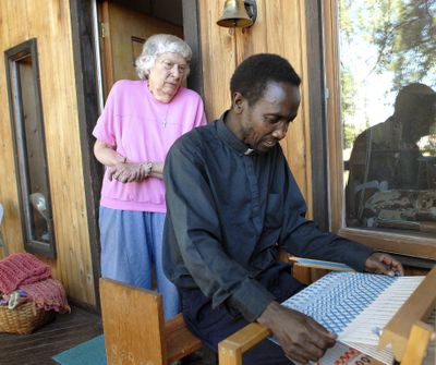 Vivian Burns, of Winchester, Idaho, helps the Rev. John Gathungu, of Nezperce, learn the many ways of spinning yarn and weaving on Aug. 17.  They are collaborating on a project they hope will restore some pride in traditional African handicrafts. (Associated Press)