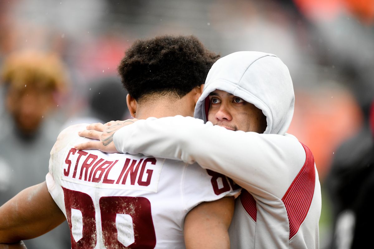 Washington State Cougars quarterback Jayden de Laura (4) wearing sweats after sitting the second half, embraces wide receiver De