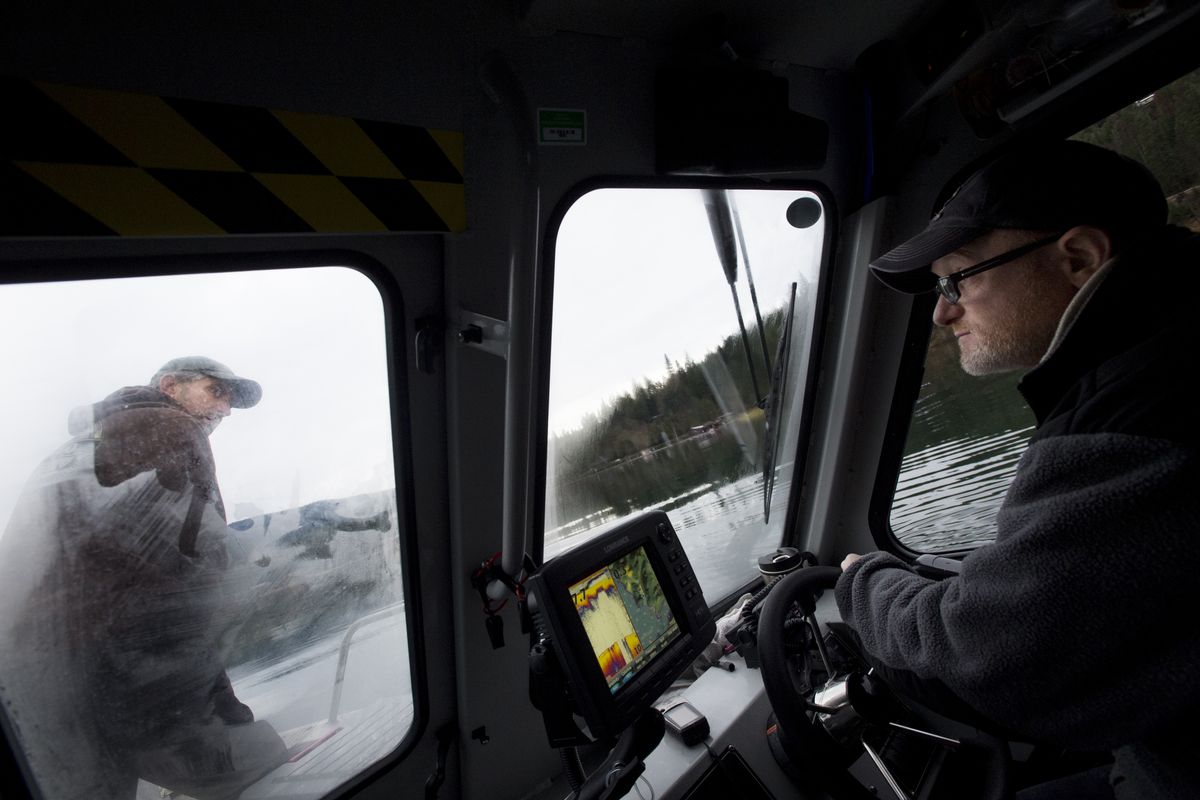 Bob Witherow, left, a technician with the Idaho Department of Environmental Quality, waits for the OK to lower an anchor at a water quality testing site Thursday while DEQ analyst Glen Petit guides their lab boat into position on Lake Coeur d’Alene. (Tyler Tjomsland)
