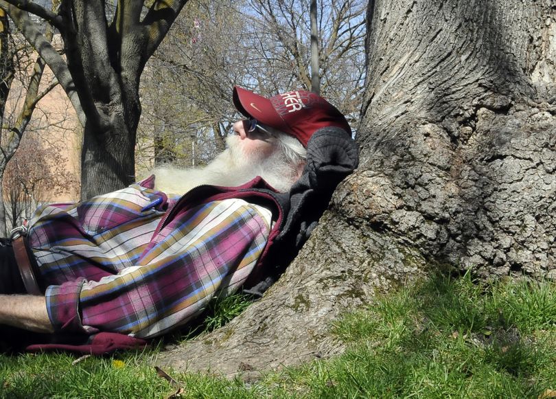 Forty winks: Jim Sorrell, 66, of Texas, takes a research break and makes his noontime home under a tree on the Gonzaga University campus Wednesday. “It has a little bit of sun and a little bit of shade,” said Sorrell on why he picked the spot outside the Crosby Center. (Dan Pelle)