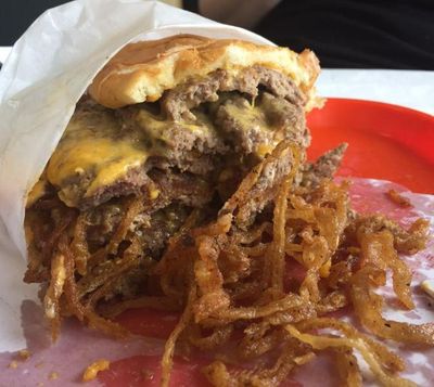 Mike Lish gives customers a knife and fork to tackle the new Karnowski burger at D. Lish in Spokane. (Pia Hallenberg / The Spokesman-Review)