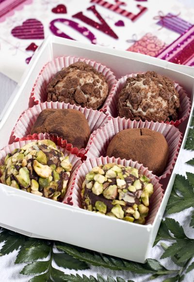 Honey-pistachio truffles, foreground, strawberry-mint truffles, center, and white chocolate-sour cream cookie truffles can be made several days in advance. (Associated Press)