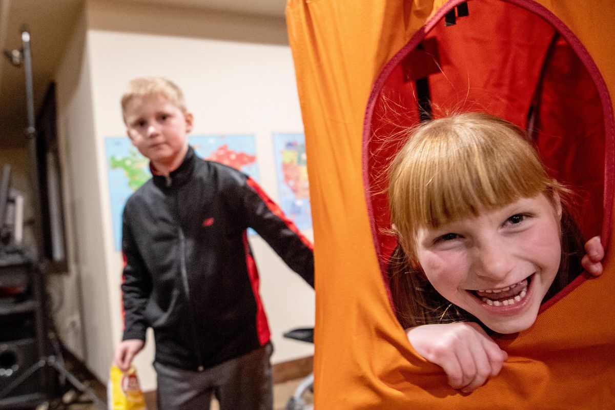 Landon Blum, 7, left, swings his six-year-old sister Elizabeth, in the family room at their home Monday, Nov. 25, 2019. Elizabeth was diagnosed with Angelman Syndrome, a congenital condition that causes delays in speech, balance and other development problems that are similar to autism. Mother Shari Blum began researching hemp extracts and began trying them on her daughter. After seeing remarkable results, she began compounding and selling tinctures for other families of kids with Angelman Syndrome. The company is Wings Tinctures. (Jesse Tinsley / The Spokesman-Review)