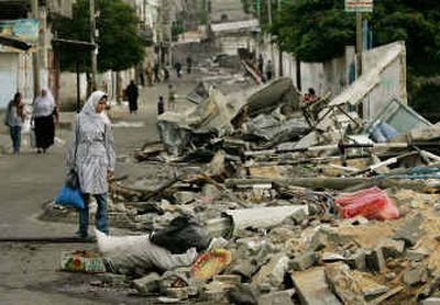 
A Palestinian student looks at the damage to a school as she walks in a street in the Jebaliya refugee camp Monday.
 (Associated Press / The Spokesman-Review)