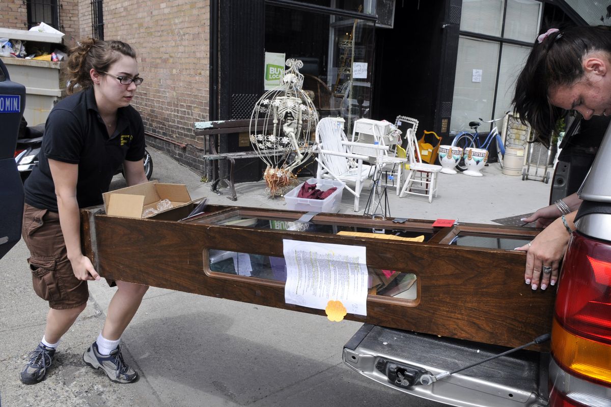 Nicole Chapman and Emily Lemcke load a jewelry cabinet into a pickup truck, taking it from the Finders Keepers location at 112 S. Cedar St. to a new store at 309 W. Second Ave. in Spokane. The Cedar Street location was damaged by a broken water pipe on June 22.  (Dan Pelle)