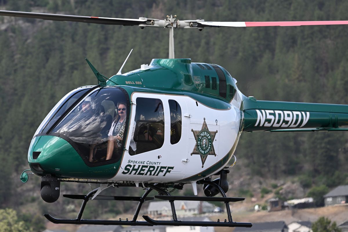 Pilot Dave Valenti of the Spokane Sheriff’s office and Spokane County Commissioner Mary Kuney are seen through the front windows of the sheriff department’s new helicopter as it takes flight after it was commissioned for service Wednesday at Felts Field. (Jesse Tinsley/The Spokesman-Review)