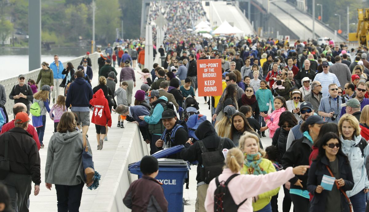 Visitors walk on the roadway of the new State Route 520 floating bridge across Lake Washington, Saturday, April 2, 2016, during a weekend grand-opening event in Seattle. The bridge will open to traffic later in the month. (Ted S. Warren / Associated Press)