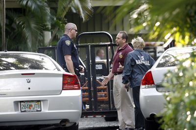 U.S. marshals, along with the Palm Beach police, are seen as they enter and secure the home of Bernard Madoff on Wednesday in Palm Beach, Fla., as part of an effort to recoup Madoff’s assets. (Associated Press / The Spokesman-Review)