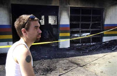 
Ryan Mullins, 22, surveys the damage to his grandfather's auto repair business after a fire early Thursday morning. A woman being chased by police crashed into Bill's Import Auto Repair, setting the structure on fire and damaging vehicles inside.
 (Jed Conklin / The Spokesman-Review)
