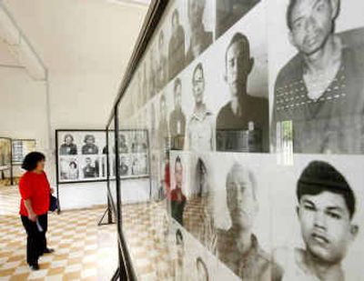 
A tourist studies portraits of prisoners on display at a former Khmer Rouge torture center in Phnom Penh on Monday. 
 (Associated Press / The Spokesman-Review)