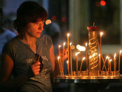 
A woman in St. Petersburg, Russia, lights a candle Saturday for the sailors who were trapped in a mini-submarine. 
 (Associated Press / The Spokesman-Review)