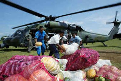 
Sri Lankan aid workers unload relief supplies Friday from a U.S. helicopter in Ampara, Sri Lanka. U.S. helicopters flew into eastern Sri Lanka Friday, ferrying some 30 tons of relief materials, including fresh fruits and vegetables, that will be delivered to more remote regions cut off by the tsunami along the eastern coast. Despite good intentions, not all supplies sent have been practical donations. 
 (Associated Press / The Spokesman-Review)
