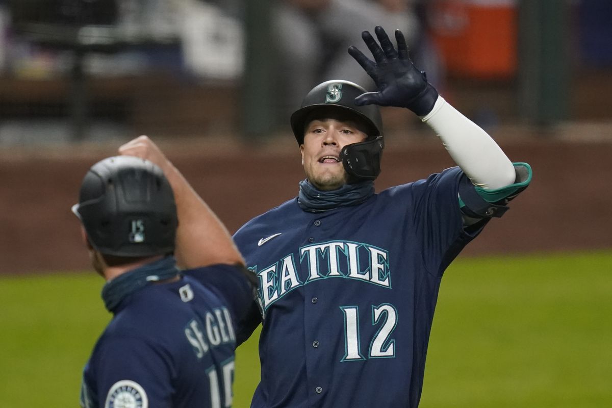 Seattle Mariners’ Evan White (12) is congratulated by Kyle Seager after hitting a three-run home run against the Houston Astros in the seventh inning of a baseball game Monday, Sept. 21, 2020, in Seattle.  (Elaine Thompson)