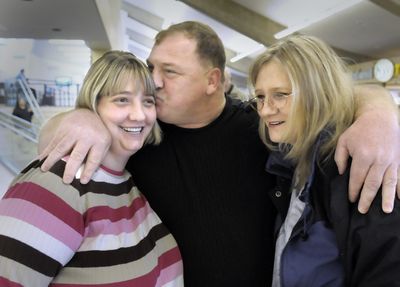 Bill Ridihalgh kisses his daughter Carol Gibson, left, as her mother, Teresa Gibson, stands at right at Spokane International Airport Nov.  1. Carol Gibson had never met her father until Saturday, after he contacted her through a MySpace page.  (CHRISTOPHER ANDERSON / The Spokesman-Review)