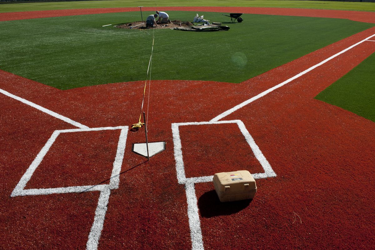 A.M. Landshaper foremen Brett Larson, left, and Jeff Mason work to finish the pitcher’s mound at Al K. Jackson Field on Thursday. Shadle Park High School’s baseball field recently underwent a conversion from grass to turf. (Tyler Tjomsland)