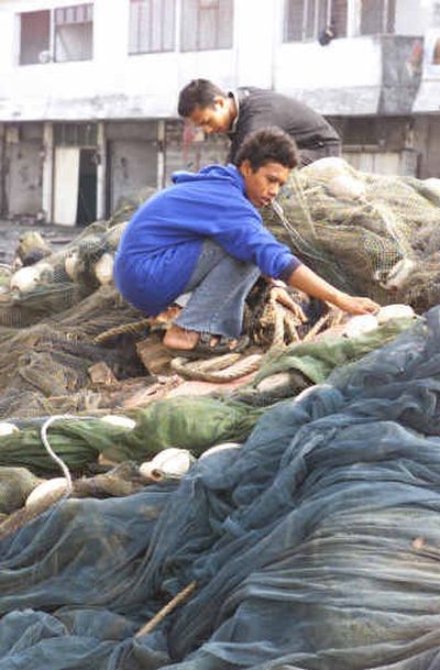 
Fishermen sort through their tangled nets, Thursday in Banda Aceh, Indonesia. Fishermen sort through their tangled nets, Thursday in Banda Aceh, Indonesia. 
 (Associated PressAssociated Press / The Spokesman-Review)