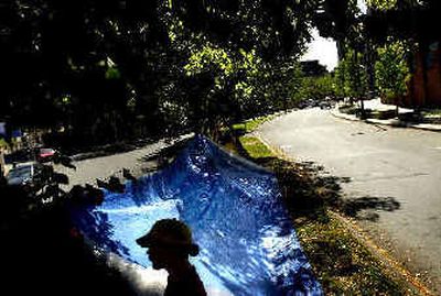 Dave Bilsland stands in the shade next to a tent along West Riverside Avenue on Tuesday morning. Several homeless people, including Bilsland, built the structure after the Spokane City Council passed an ordinance prohibiting camping on public property.
(Brian Plonka / The Spokesman-Review)