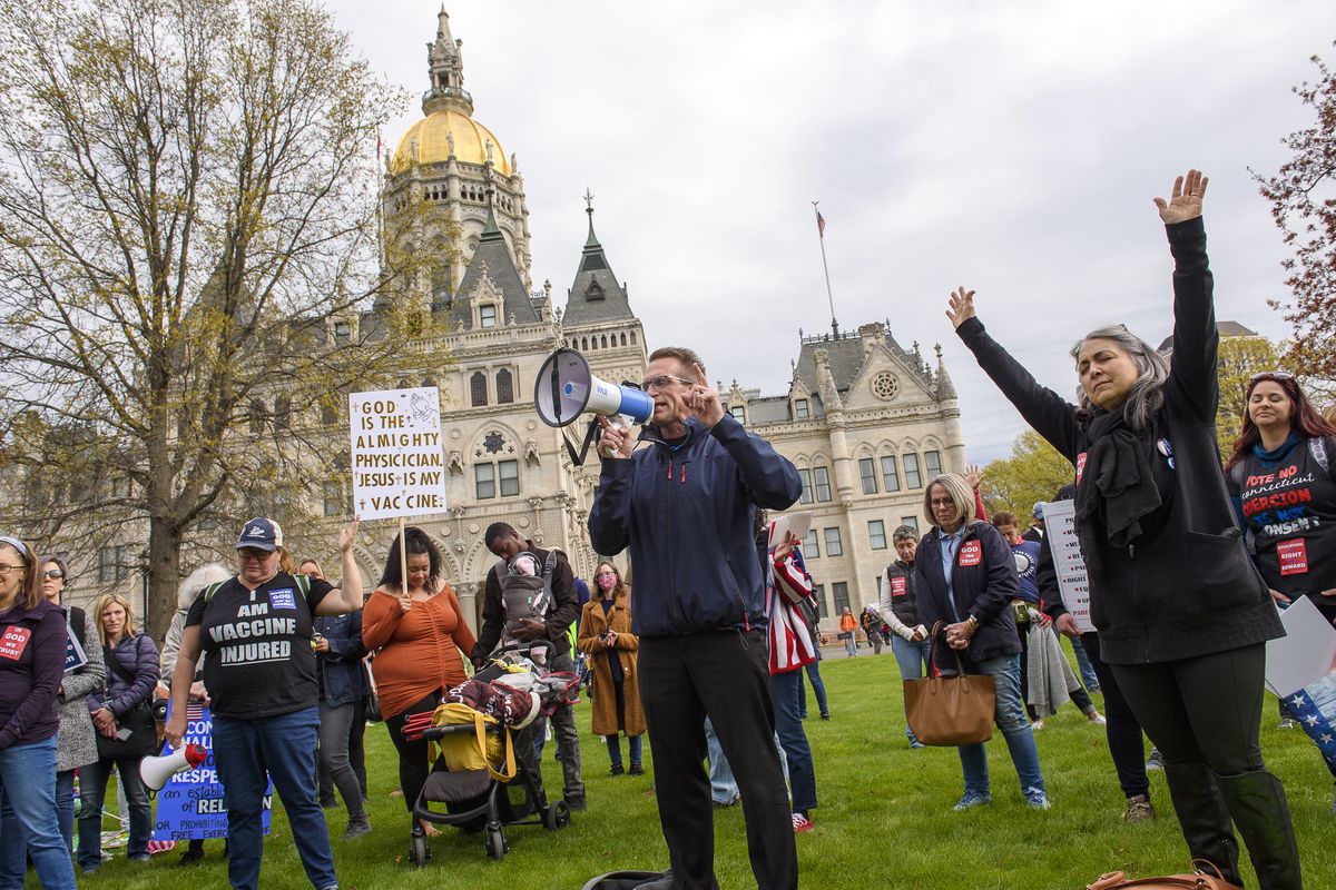 Joining thousands gathered outside the State Capitol, opponents of a bill to repeal Connecticut's religious exemption for school vaccinations pray outside the Capitol before the State Senate voted on the legislation, Tuesday, April 27, 2021, in Hartford, Conn. Religious exemptions like the one eliminated by Connecticut’s new law are facing particular scrutiny amid fears of new measles outbreaks and concerns the growing number of families claiming religious exemptions for their children are opposed because of scientifically discredited claims about the dangers of vaccines.  (Mark Mirko)