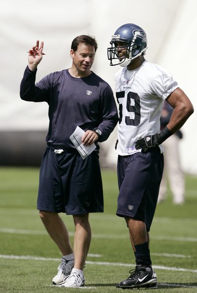 Coach Jim Mora shares thoughts with Julian Peterson.  (Associated Press / The Spokesman-Review)