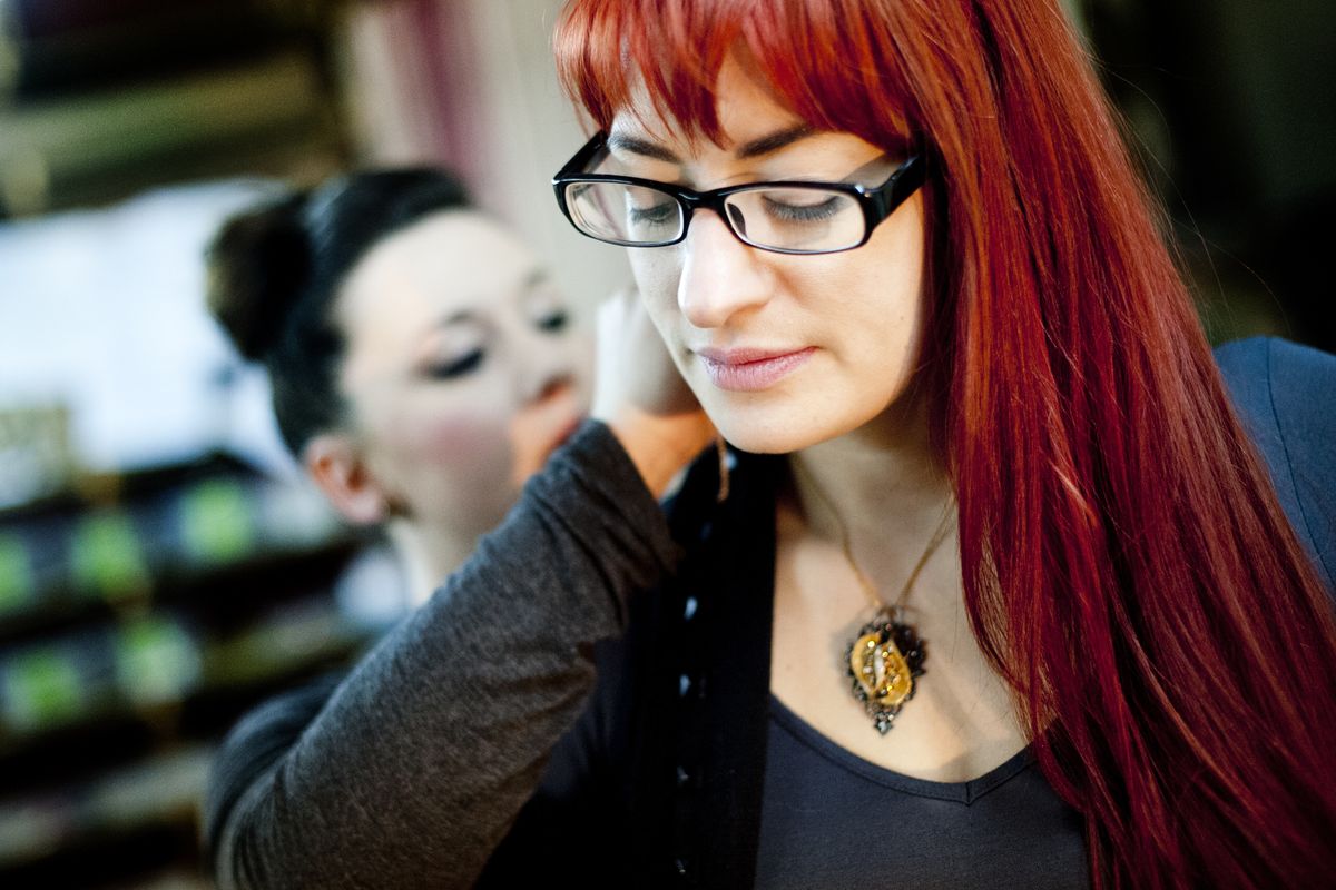 Shelby Morton of Spokane, helps jewelry designer Alyssah Perez into one of Perez’s necklaces before a photo shoot at Eco Chic Jewelry Designs Feb. 21 at Glamarita in the Garland Business District in north Spokane. Perez now owns a working studio and Morton is her first employee. (Tyler Tjomsland)