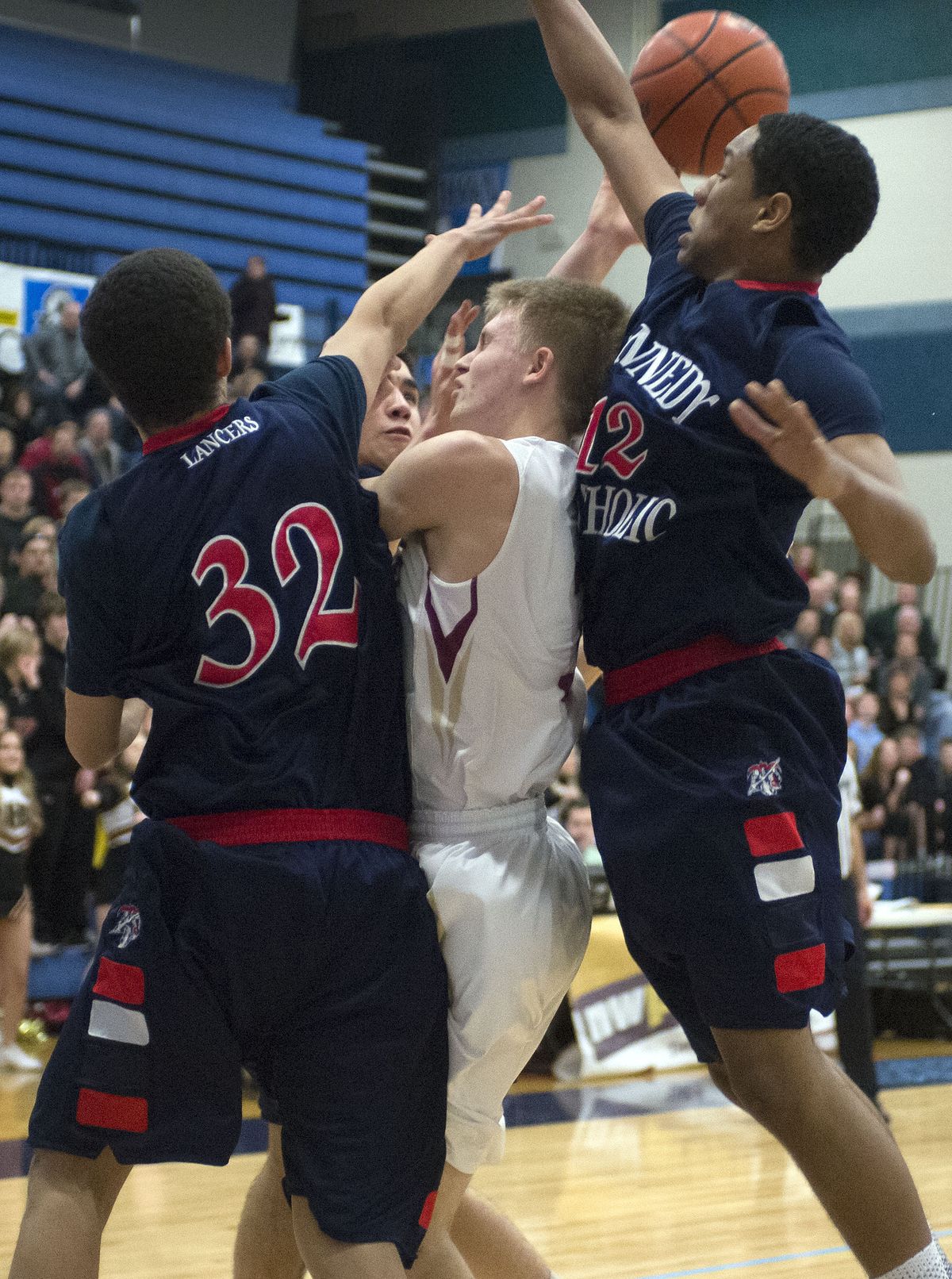 As Kennedy Catholic’s Spencer Weisberg (32) and AJ McGrew defend, University’s Michael Isotalo, center, loses control of the ball during the first half on Feb. 28.