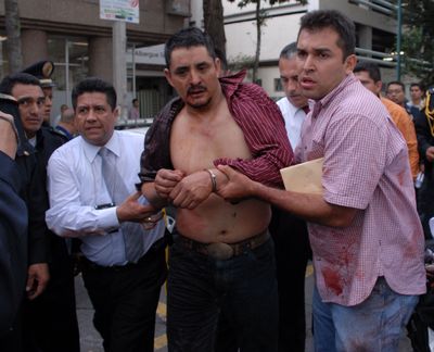 Police officials arrest a suspected gunman at the site of an attack at a subway station in Mexico City on Friday.  Two people were killed and five wounded.  (Associated Press / The Spokesman-Review)