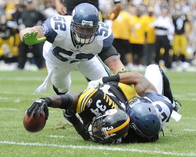 Steelers’ Rashard Mendenhall is tackled short of goal line by Seahawks’ Marcus Trufant as Matt McCoy (52) closes in during the first quarter. (Associated Press)