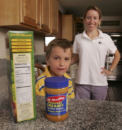 Margaret Sova McCabe and her son, Tommie, pose in her kitchen with some of the foods Tommie can eat. Said McCabe: “Really, the safest thing you can do is make all your food at home from scratch, period.” One of the biggest frustrations of life with food allergies is the confusing warnings that say a food might accidentally contain the wrong ingredient. (Associated Press / The Spokesman-Review)