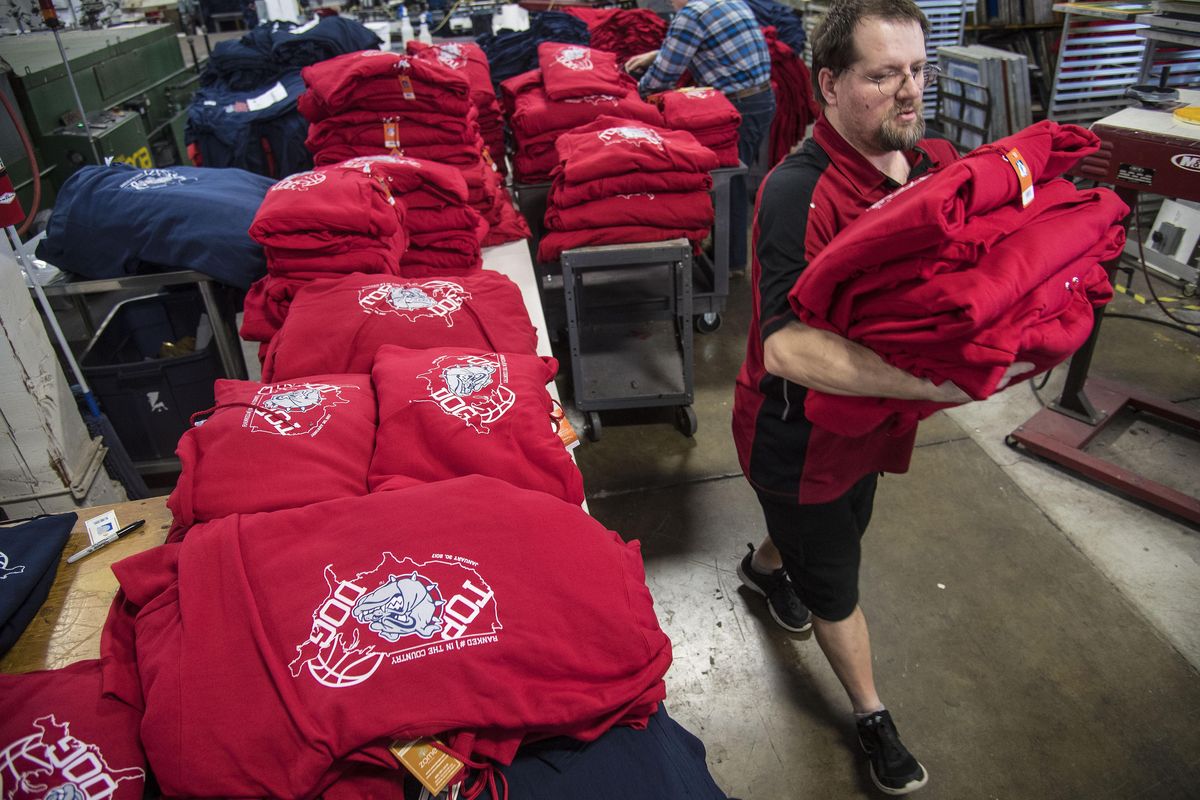 Ken Huck, of Zome Design, packs away an armful of Gonzaga Top Dog shirts, Feb. 3, 2017, in Spokane Valley, Wash. The shirts commemorate Gonzaga University’s No. 1 ranking in basketball polls. Huck works in the embroidery department but was brought into the back to help fill the huge order. (Dan Pelle / The Spokesman-Review)