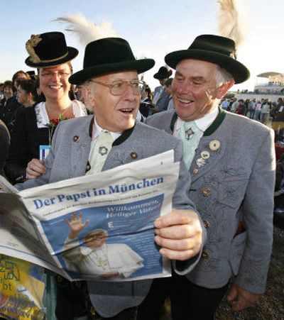 
Pilgrims in traditional Bavarian garb from Raubling read a special edition of a newspaper  prior to the beginning of a Mass with Pope Benedict XVI  in Munich, Germany, Sunday morning. 
 (Associated Press / The Spokesman-Review)