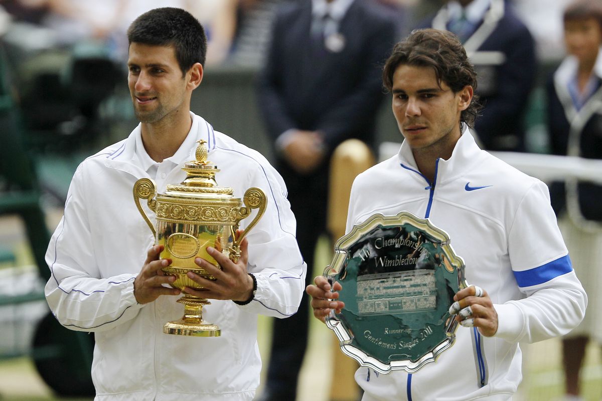 Serbia's Novak Djokovic and Spain's Rafael Nadal, right, hold their trophies after Djokovic defeated Nadal in the men's singles final at Wimbledon. (Associated Press)
