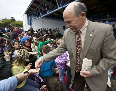 Coin program: Washington first gentleman Mike Gregoire hands out coins to students following the Olympic National Park Quarter Launch in Port Angeles, Wash., on Tuesday. One side of the quarter honors the park with a depiction of a Roosevelt elk standing on a Hoh River gravel bar with Mount Olympus in the background. The coin is part of the America the Beautiful Quarters Program. (Associated Press)