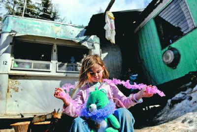 
Jacenta Bonagofski, 6, enjoys the warm morning sun  in front of her home in Rapid Lightning, Idaho, on March 14. Her family lives in a small trailer. They have no running water and their only source of electricity is a generator, but her parents say love is more important than material comforts. 
 (Photos by KATHY PLONKA / The Spokesman-Review)