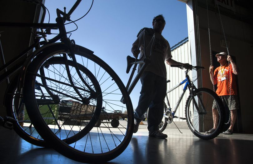 Mike Ramsey, of Nine Mile Falls, rolls one of his 19 bikes he brought to the 2016 Spokane Bike Swap & Expo, into the Spokane County Fair & Expo grounds past volunteer Tom Surbrook, right, Friday, April 8, 2016. Ramsey gets his bikes at auction, then repairs them for sale. Nine hundred new and used bikes are expected to on display for the one-day Saturday sale 9 a.m.-5 p.m. Proceeds go to help preserve the Spokane River Centennial Trail. (Dan Pelle / The Spokesman-Review)