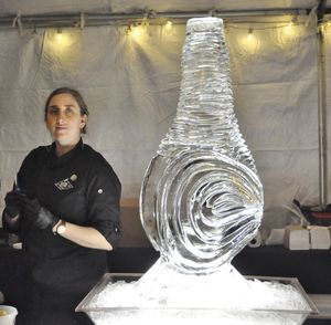 OLYMPIA -- Clara Varadi-True stands next to the ice sculpture decorates the oyster bar set up by the Taylor Shellfish Co. table at the Inaugural Ball reception.  (Jim Camden/The Spokesman-Review)