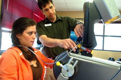 
Physical therapist Mark Feasline sets up client Darci Johnson with a machine recently to help her strengthen her back at RehabAuthority, a new physical therapy clinic in Post Falls. 
 (Jesse Tinsley / The Spokesman-Review)