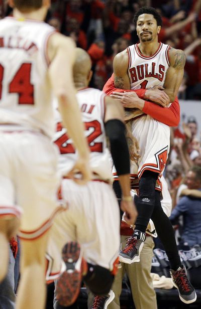 Chicago’s Derrick Rose, right, celebrates 99-96 win over Cleveland. (Associated Press)