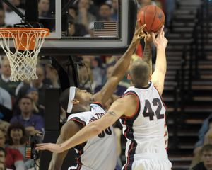 Ira Brown ( left ) and Josh Heytvelt (right ) combine to reject the shot of Jeremy Evans of Western Kentucky. (Christopher Anderson / The Spokesman-Review)