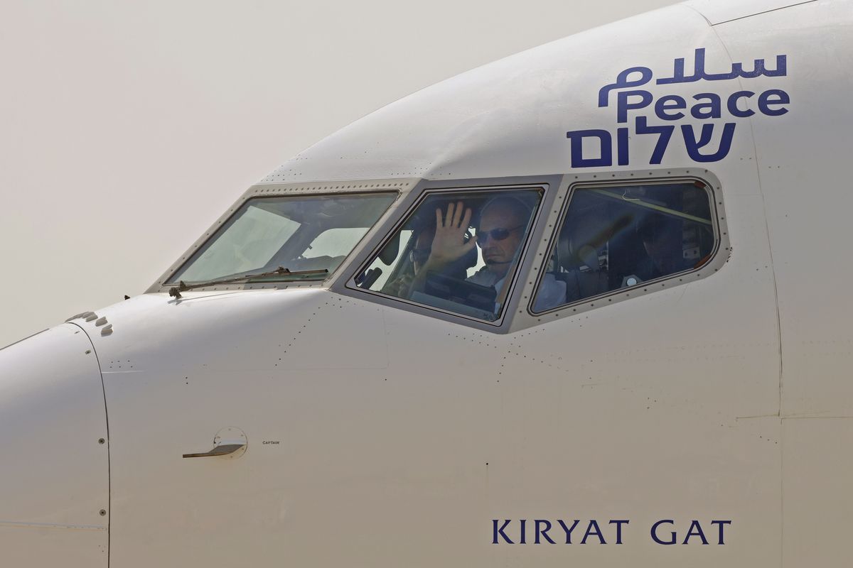 The captain of the El Al airliner which will carry US and Israeli delegations to the United Arab Emirates waves to spectators as the plane prepares to take off on the first-ever commercial flight from Israel to the UAE, at Ben Gurion Airport near Tel Aviv, Israel, Monday, Aug. 31, 2020. (Menahem Kahana)