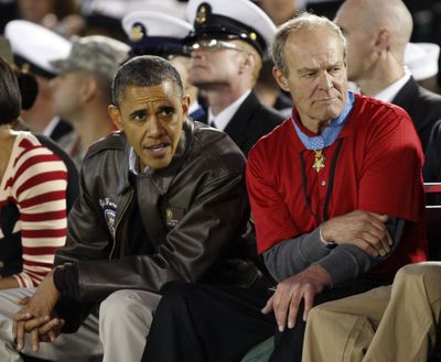 President Barack Obama watches the Carrier Classic between Michigan State and North Carolina with Medal of Honor recipient John Baca on Friday in Coronado, Calif. (Associated Press)